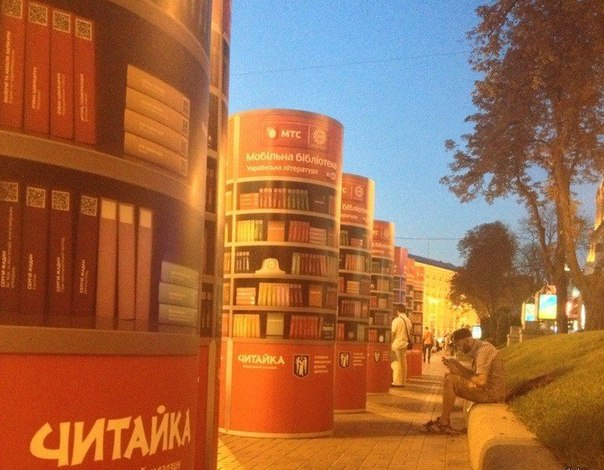 Вот такие штуки установил МТС в Киеве. Суть в том, что эти тумбы раздают WiFi, а на каждой нарисованной книге есть QR-код, ты код считываешь и грузишь книгу.